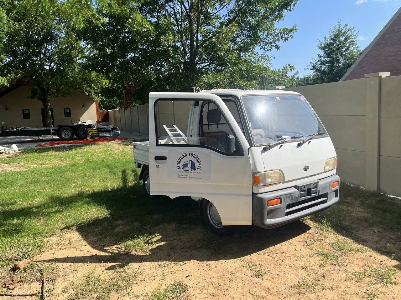 TubeCrete work truck beside a completed precast concrete fence