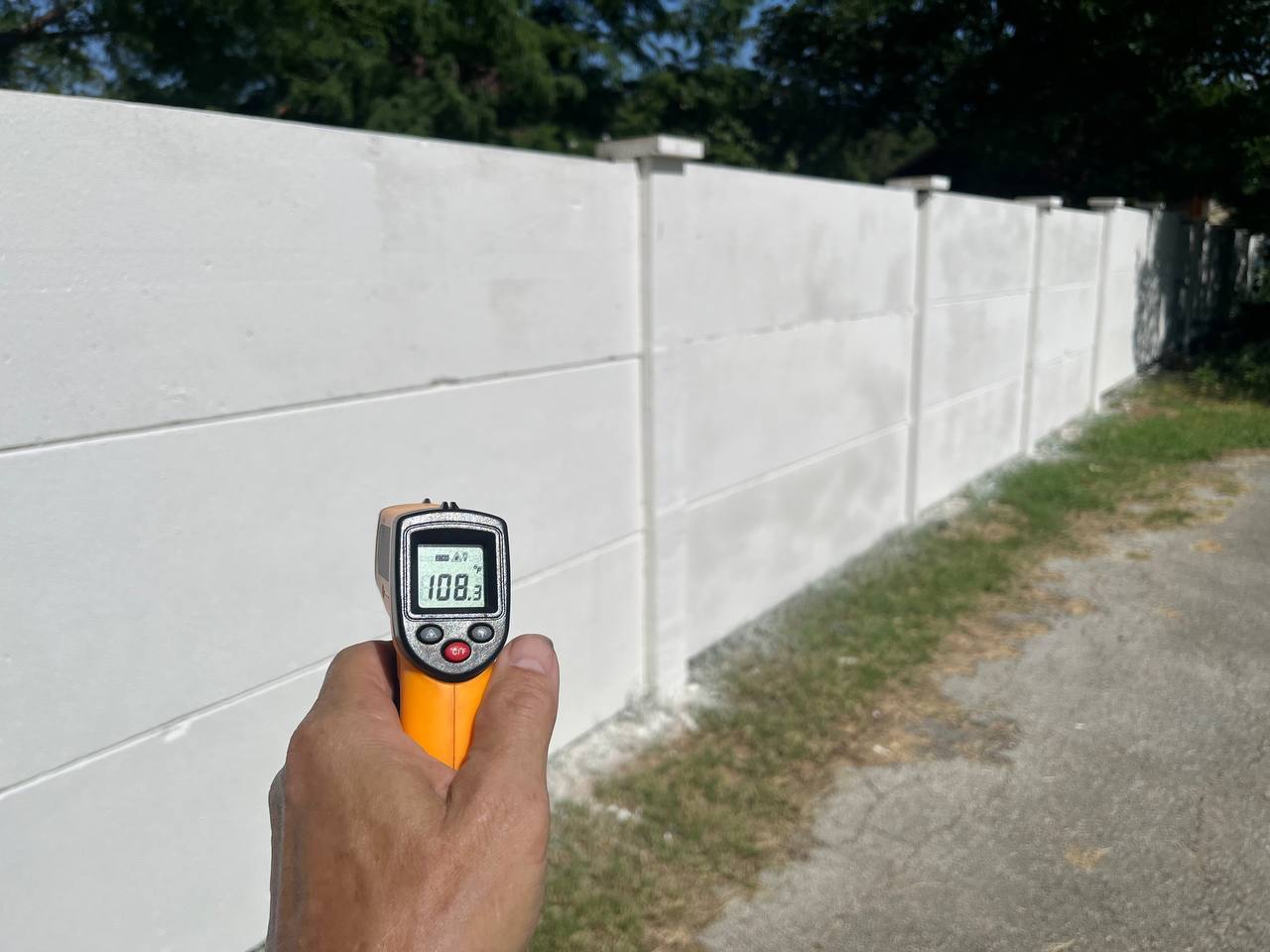 Infrared thermometer reading the surface temperature of a precast concrete fence panel